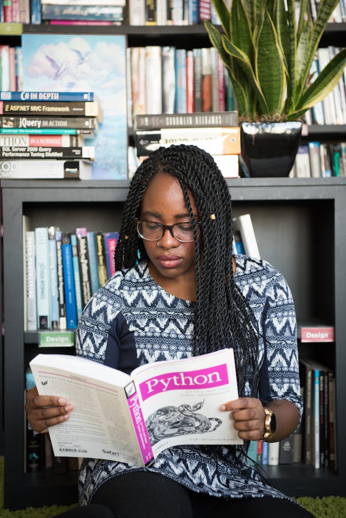 service-02 African American woman studying Python programming in a library setting.
